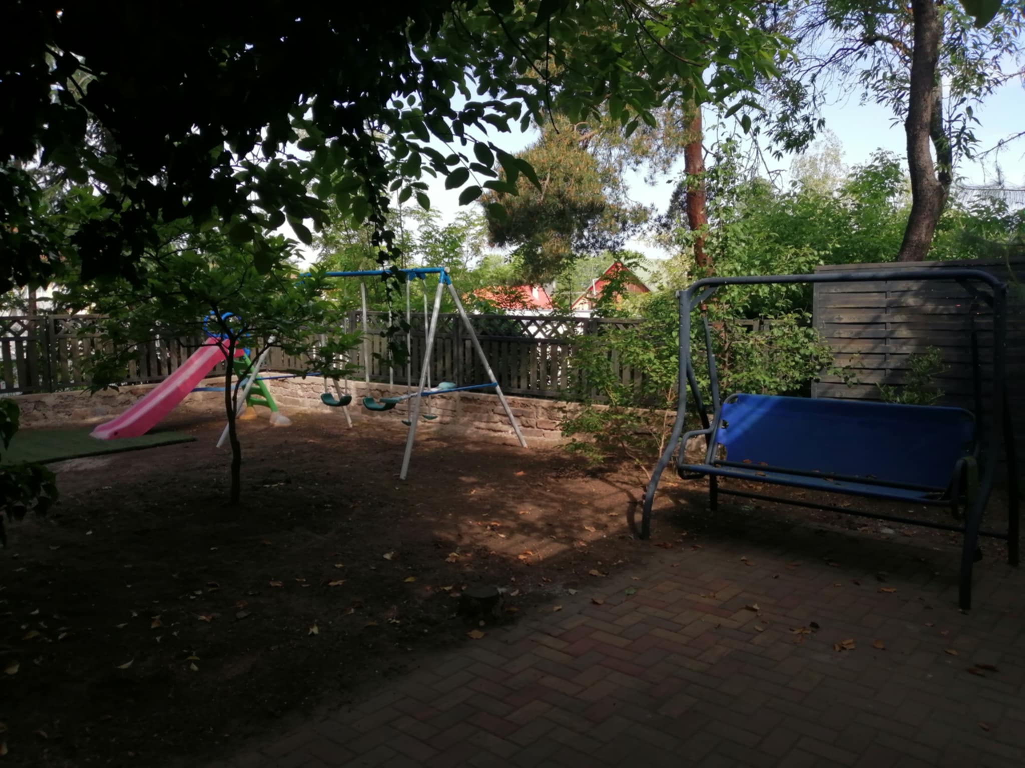 Játszótér az udvaron csúszdával és hintával